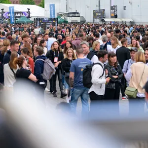 Zahlreiche Messe-Besucher stehen zwischen den Messehallen.