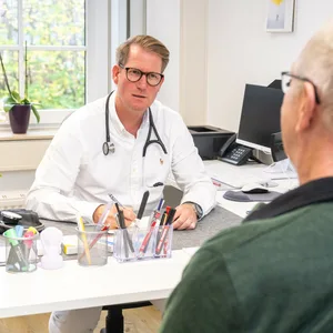 Ein Patient sitzt vor einem Arzt.