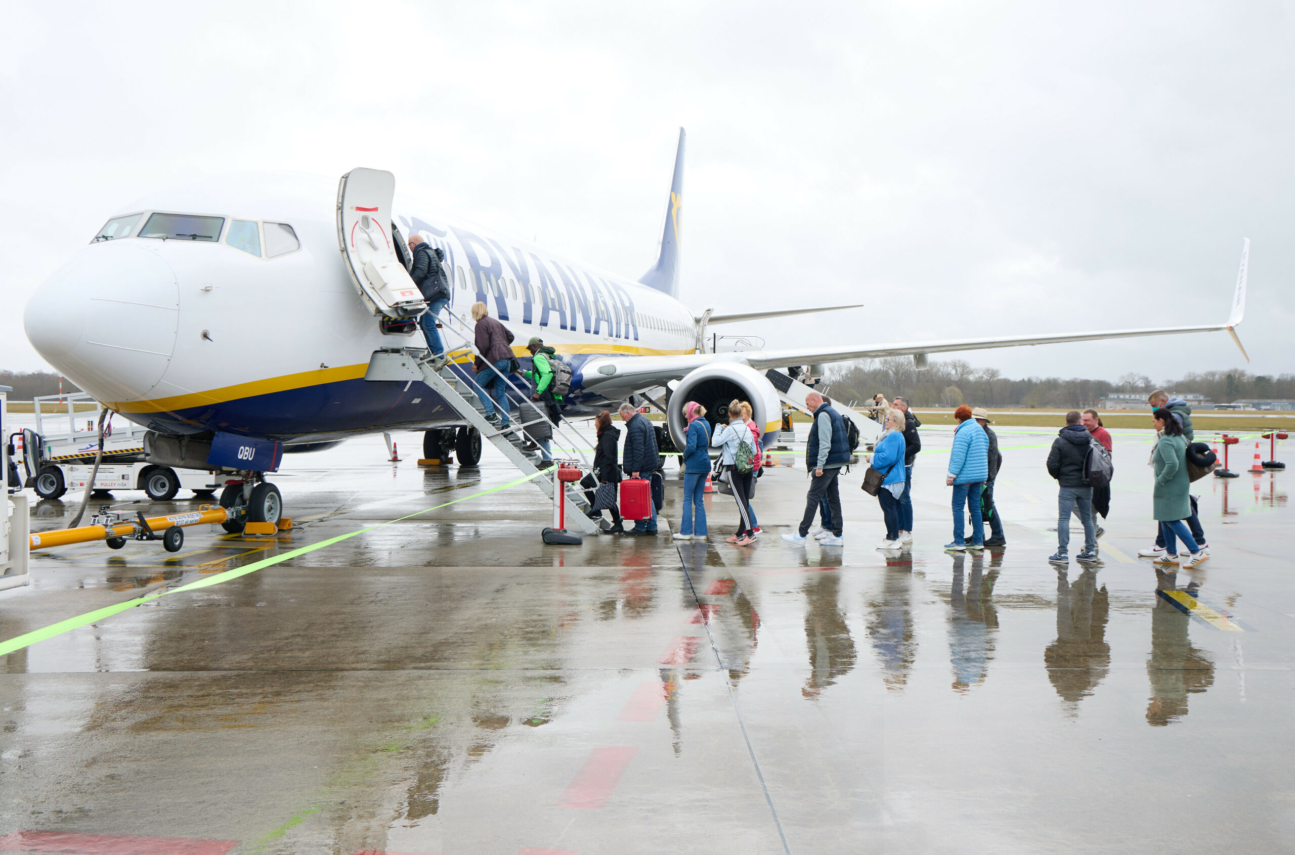 Passagiere steigen auf dem Flughafen Lübeck in ein Flugzeug.