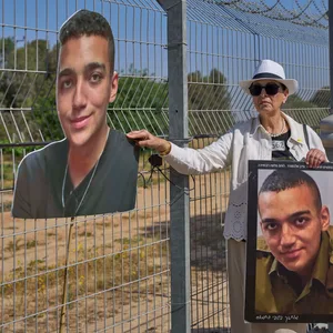 Varda Ben Baruch an der Grenze zum Gazastreifen mit Porträts ihres Enkels Edan Alexander.