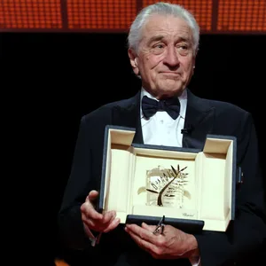 Robert De Niro hält seine Auszeichnung der Goldenen Ehrenpalme in der Hand.