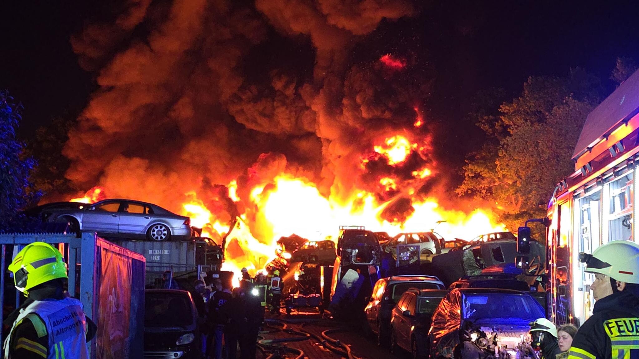 Feuerwehrleute arbeiten an einem Großbrand in Recyclingfirma.