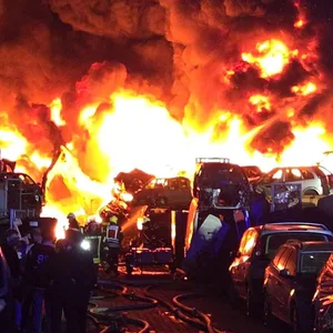 Feuerwehrleute arbeiten an einem Großbrand in Recyclingfirma.