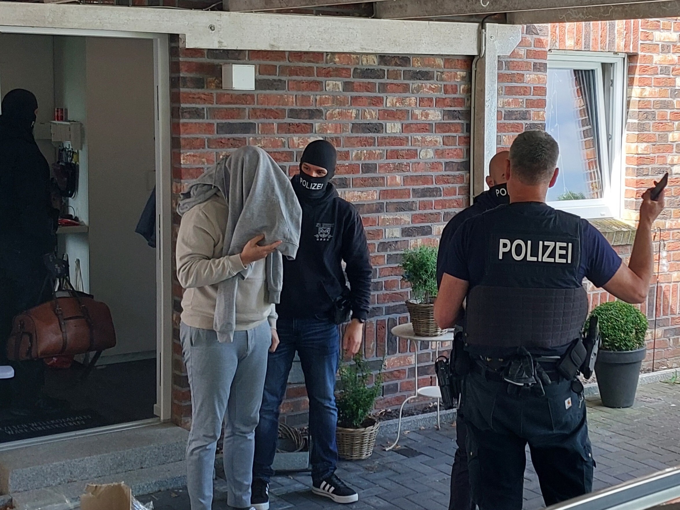 Polizisten bei der Vollstreckung eines Haftbefehls gegen den Hauptbeschuldigten im Rahmen der Razzia.