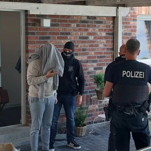 Polizisten bei der Vollstreckung eines Haftbefehls gegen den Hauptbeschuldigten im Rahmen der Razzia.