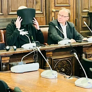 Damian M. (33, mit Mappe vorm Gesicht) und sein Dolmetscher während des Prozesses vor dem Landgericht Hamburg. (Archivbild)
