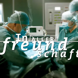 Das Logo der Sendung „In aller Freundschaft“ ist vor einer Operationsszene zu sehen.