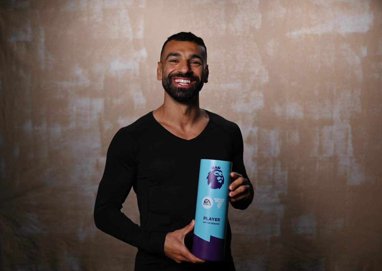 Mohamed Salah lächelt in die Kamera mit der Trophäe „Player of the Season“
