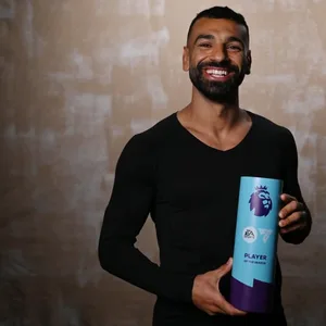 Mohamed Salah lächelt in die Kamera mit der Trophäe „Player of the Season“