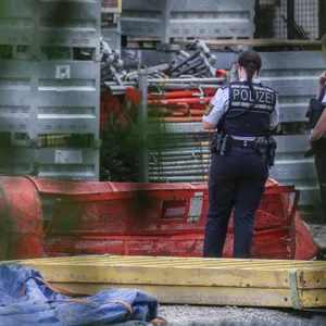 Einsatzkräfte der Polizei stehen auf der Hochbrücken-Baustelle neben einer Gondel.