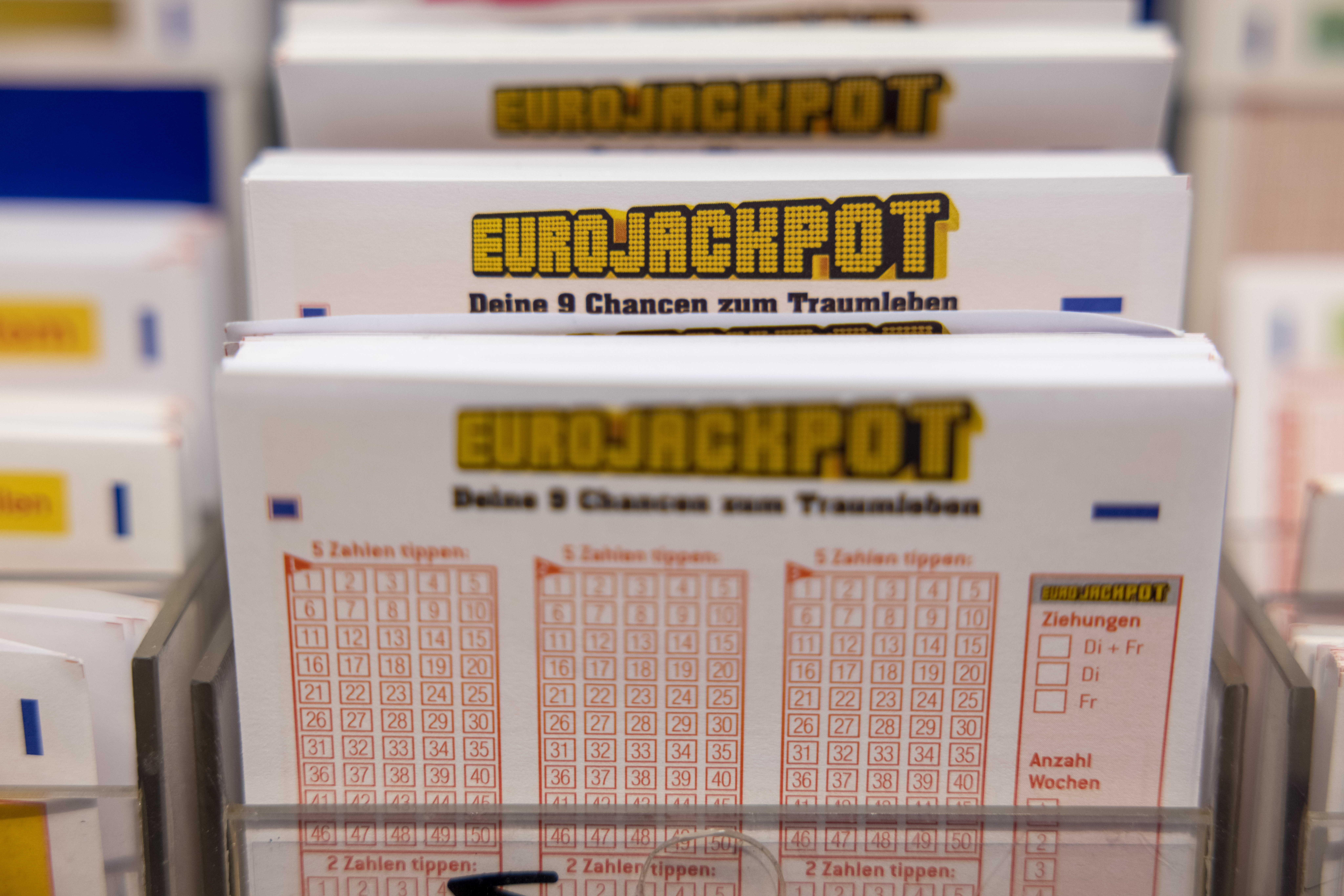 Eurojackpot-Spielscheine stehen in einem Regal in einer Lotto-Annahmestelle. (Symbolbild)