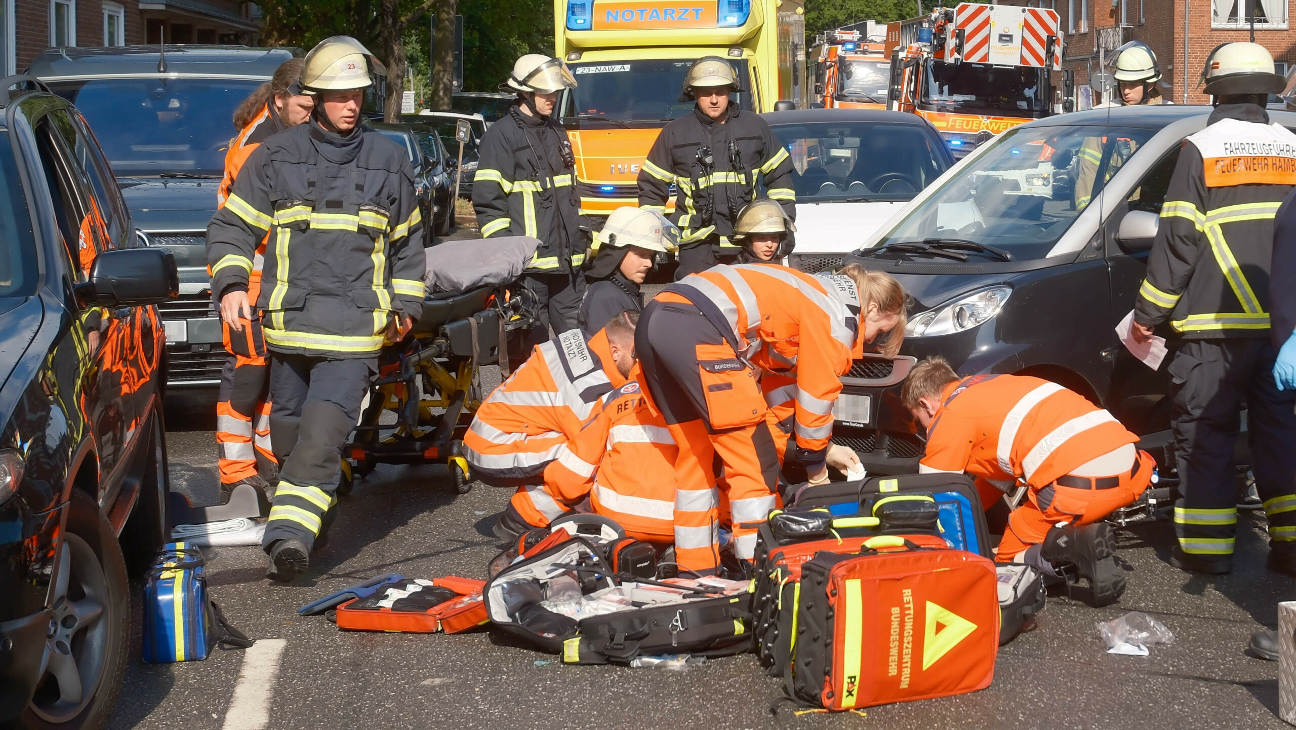 Rettungskräfte behandeln den verletzten Radfahrer auf der Walddörferstraße in Hamburg-Wandsbek.