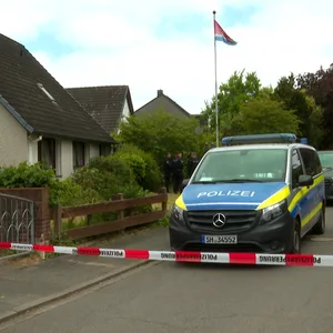 Ein Polizeiwagen vor einem Einfamilienhaus