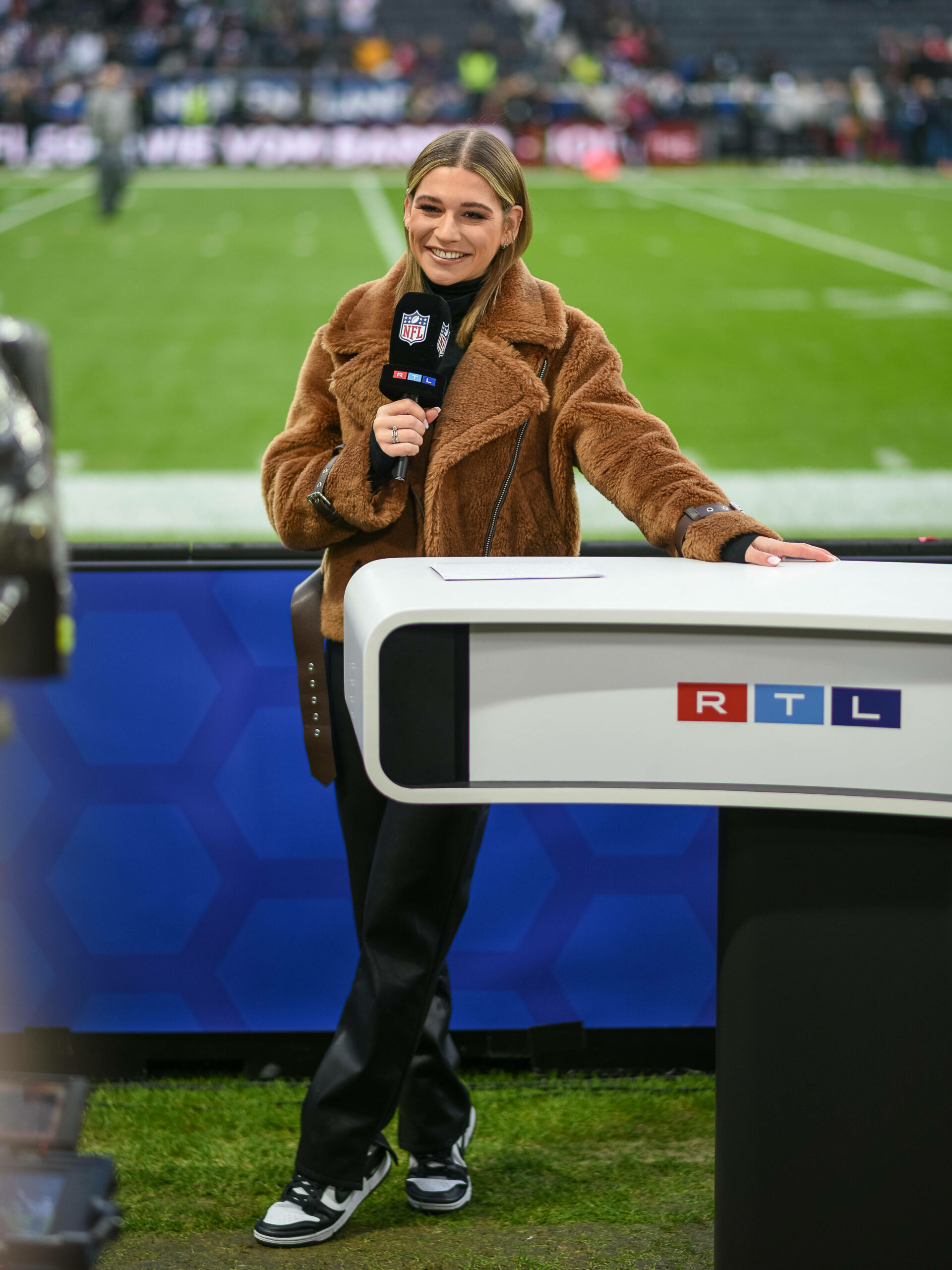 Jana Wosnitza steht am RTL-Pult und lächelt