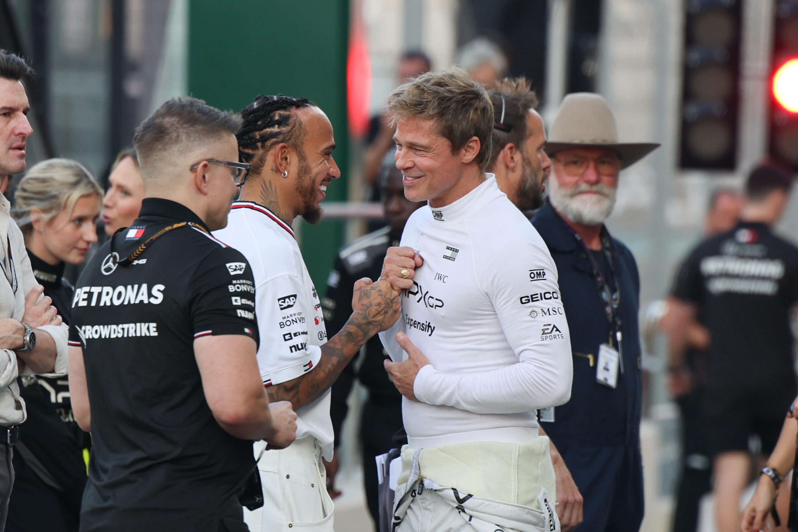 Lewis Hamilton und Brad Pitt klatschen ab.