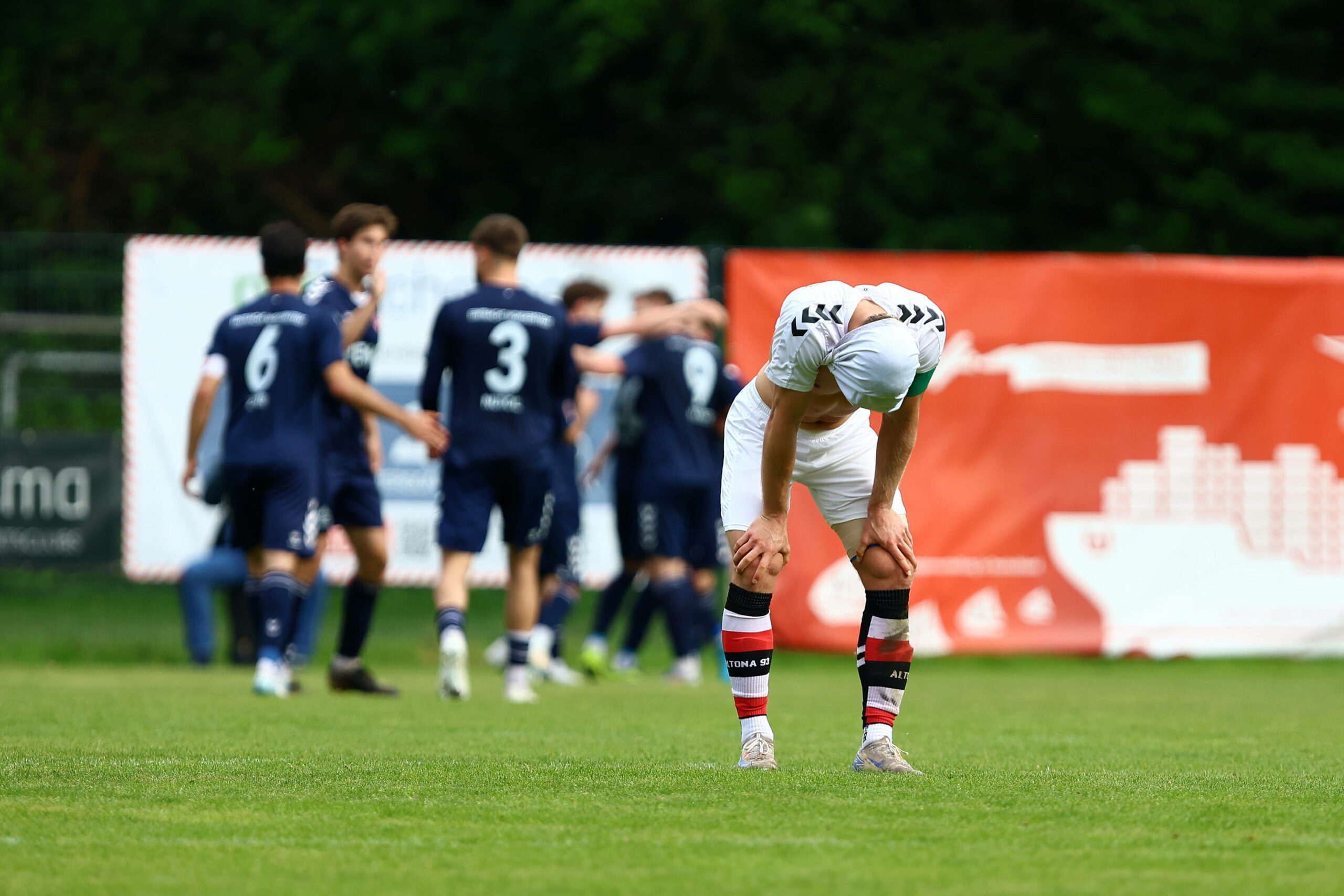 Rasmus Tobinski stützt die Hände auf die Knie und hat sich das Trikot über den Kopf gezogen
