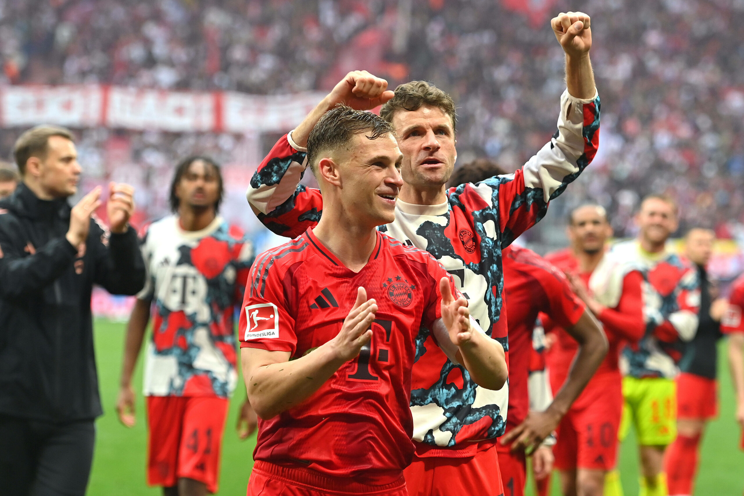 Joshua Kimmich feiert mit Thomas Müller vor den Bayern-Fans.