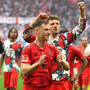 Joshua Kimmich feiert mit Thomas Müller vor den Bayern-Fans.