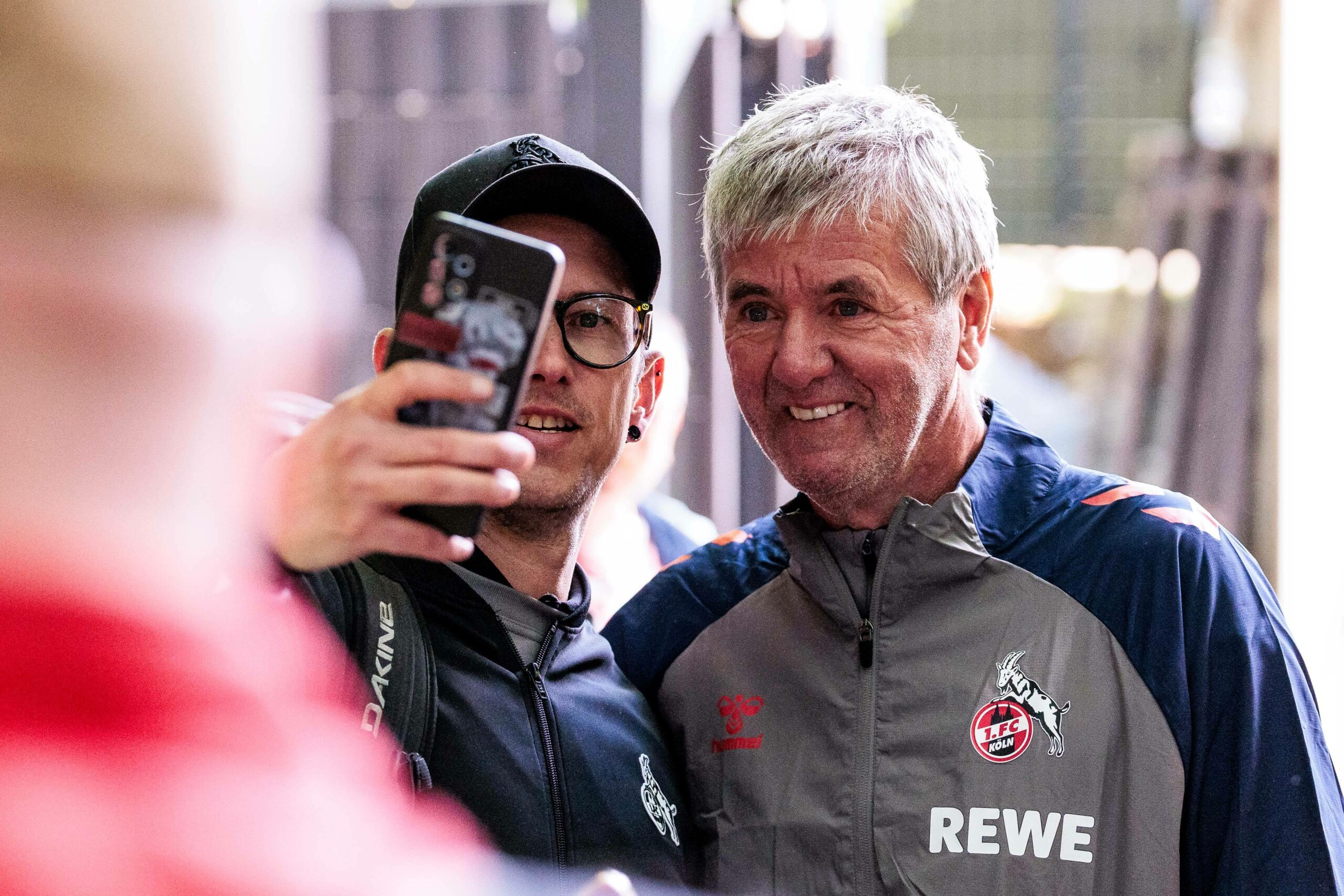 Ein Fan vom FC Köln macht ein Selfie mit Köln-Cheftrainer Friedhelm Funkel