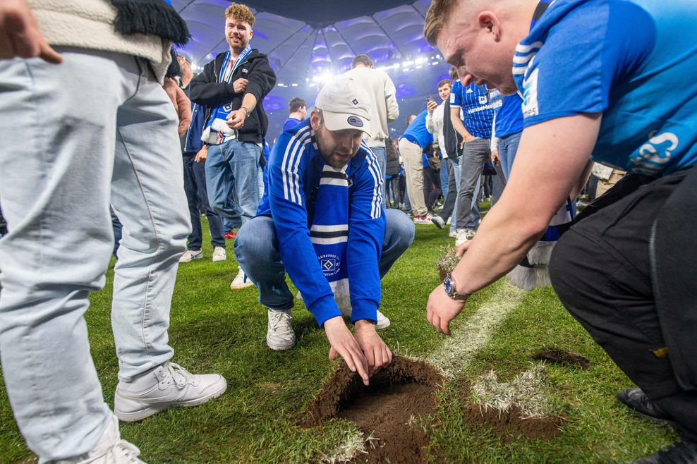 Auf ihn mit Gebrüll! Die HSV-Fans bedienen sich und schnappen sich ein Stück des Aufstiegsrasens.