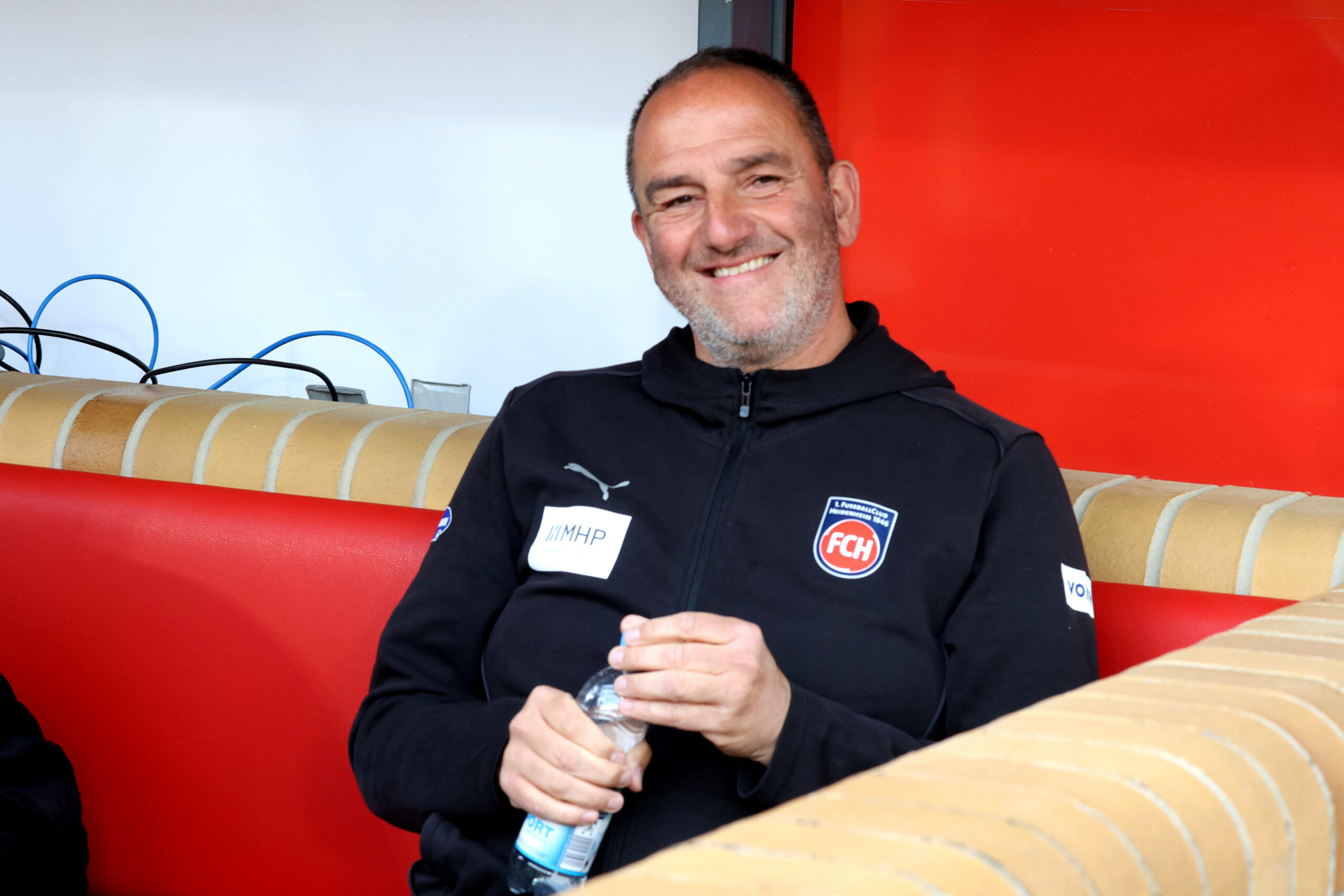 Frank Schmidt sitzt und lächelt in die Kamera