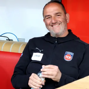 Frank Schmidt sitzt und lächelt in die Kamera