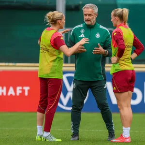 Bundestrainer Christian Wück diskutiert mit Laura Freigang (l.) und Lea Schüller.