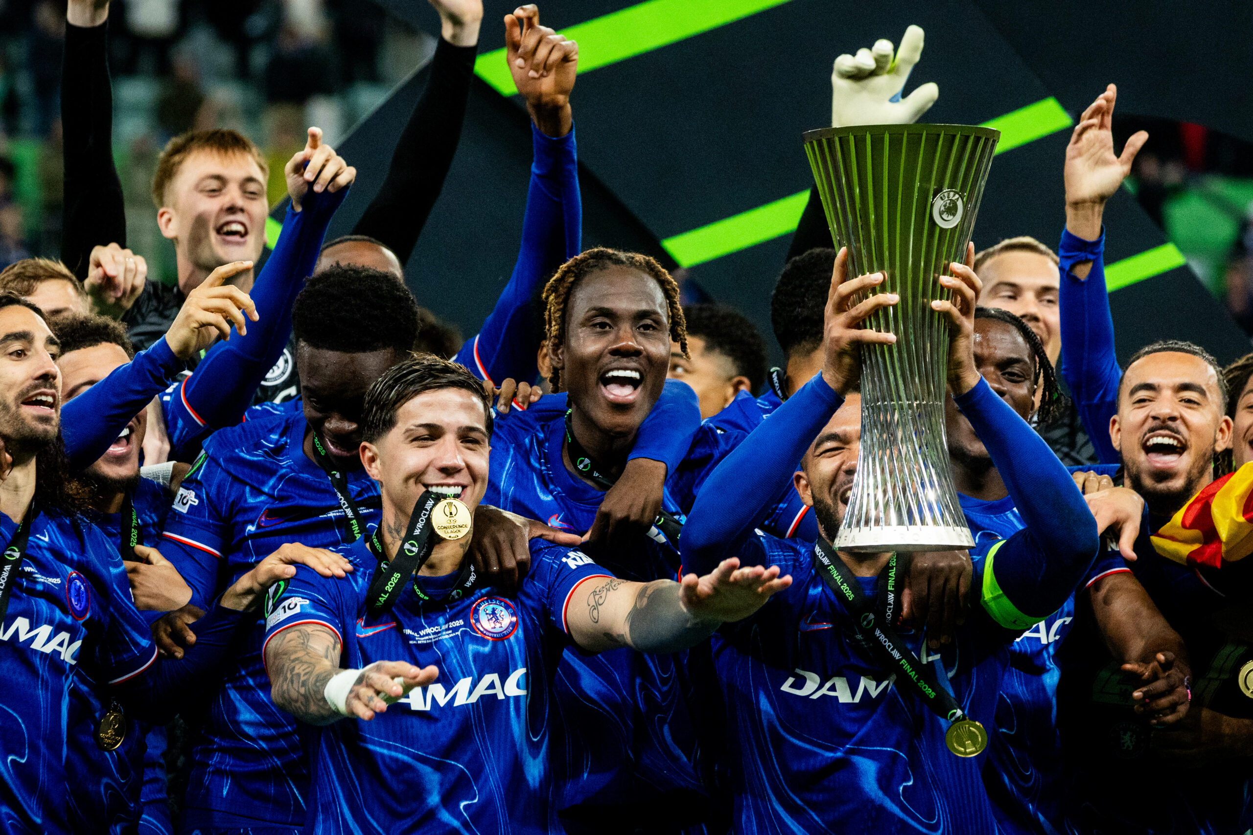 Reece James hebt die Conference League Trophäe in die Luft und seine Mitspieler jubeln mit.