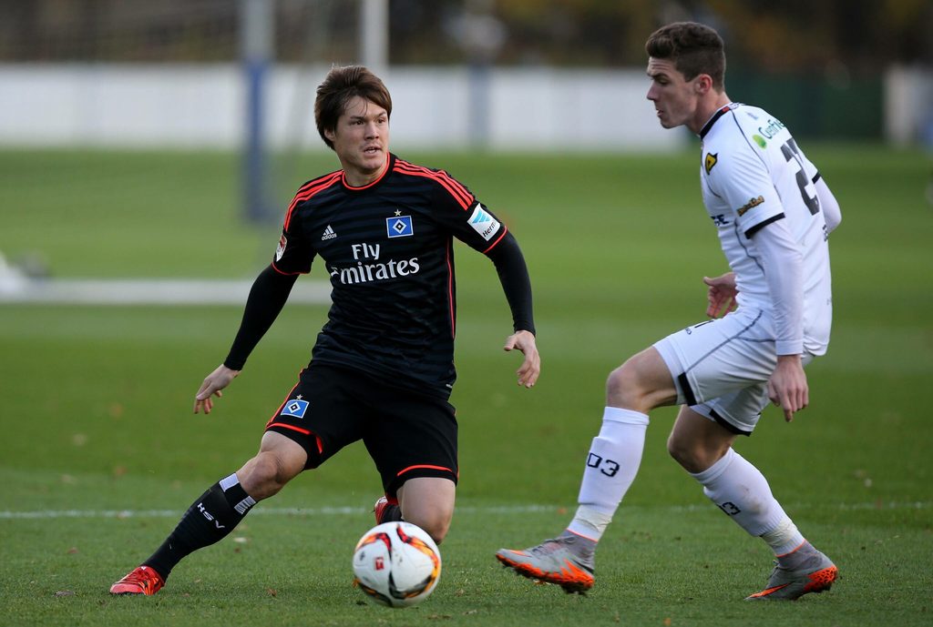 Gotoku Sakai spielt einen Pass vor Robin Gosens