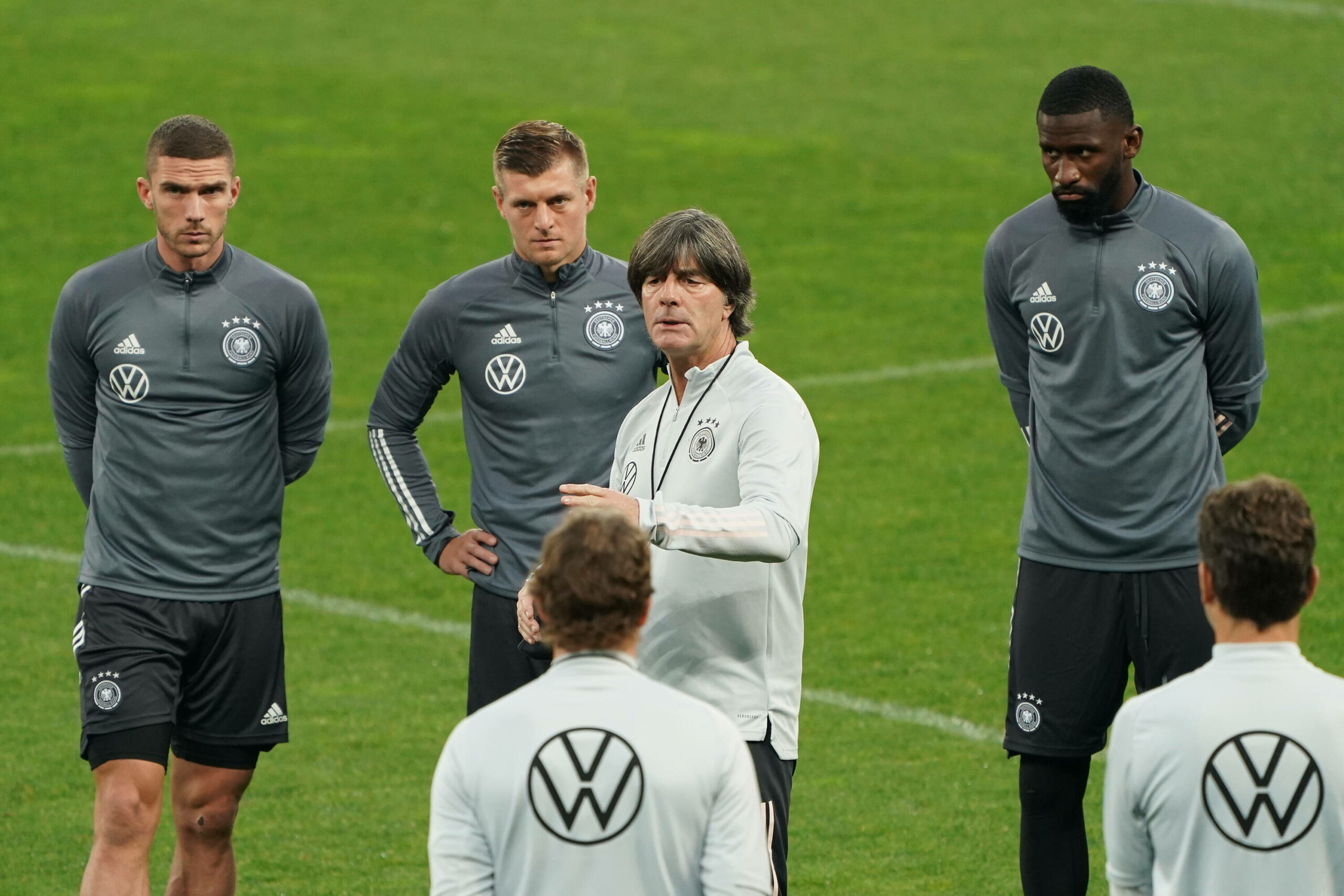 Robin Gosens, Toni Kroos und Antonio Rüdiger hören einer Ansprache von Jogi Löw zu