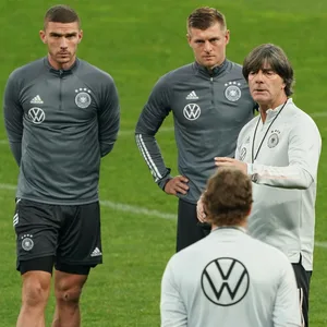 Robin Gosens, Toni Kroos und Antonio Rüdiger hören einer Ansprache von Jogi Löw zu