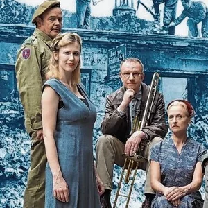 Eine Familie steht vor einer Kulisse zertrümmerter Gebäude.
