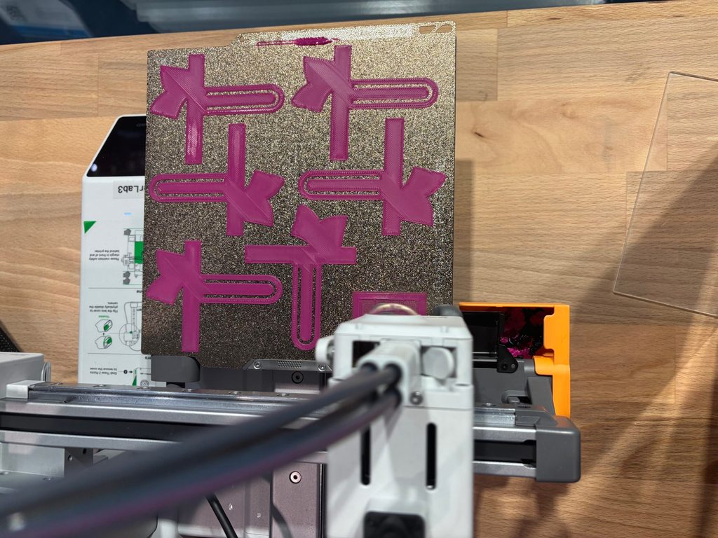 Eine Stickmaschine stickt die Aufschrift „MakerLab“ auf ein Stück Stoff.