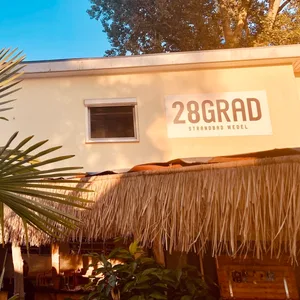 Schild „28 Grad“ vor blauem Himmel