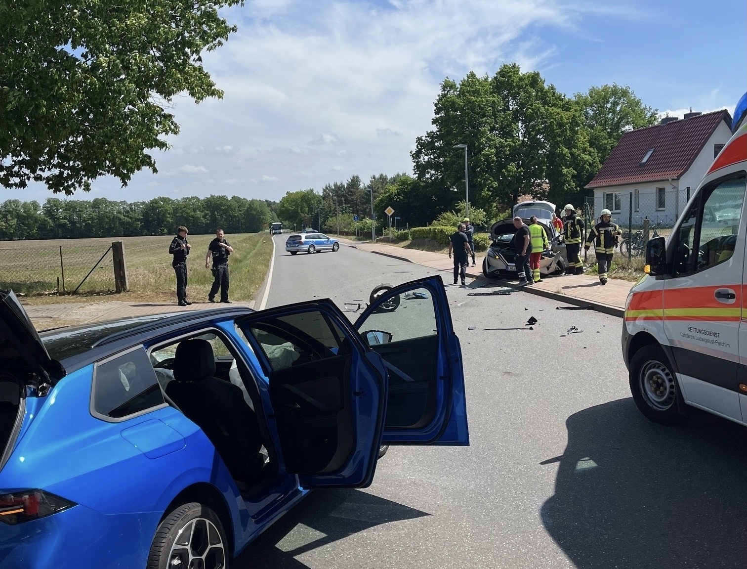 Ein Auto und ein Krankenwagen stehen auf der Straße. Auf dem Fußgängerweg sind Einsatzkräfte