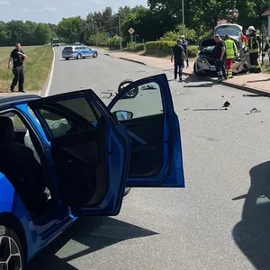 Ein Auto und ein Krankenwagen stehen auf der Straße. Auf dem Fußgängerweg sind Einsatzkräfte