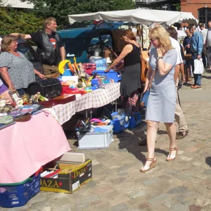 Menschen stehen an Flohmarktständen.