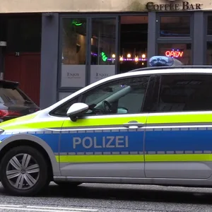 Ein Streifenwagen vor dem Café „Enjoy“ an der Wilstorfer Straße in Hamburg-Harburg.