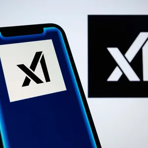 Logos von Elon Musks KI-Firma xAI auf einem Smartphone und einem Bildschirm. Bei xAI wurde der Chatbot Grok entwickelt, der unter anderem über die Online-Plattform X verfügbar ist.