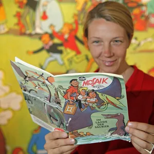 Eine Frau blättert in einem Comic.
