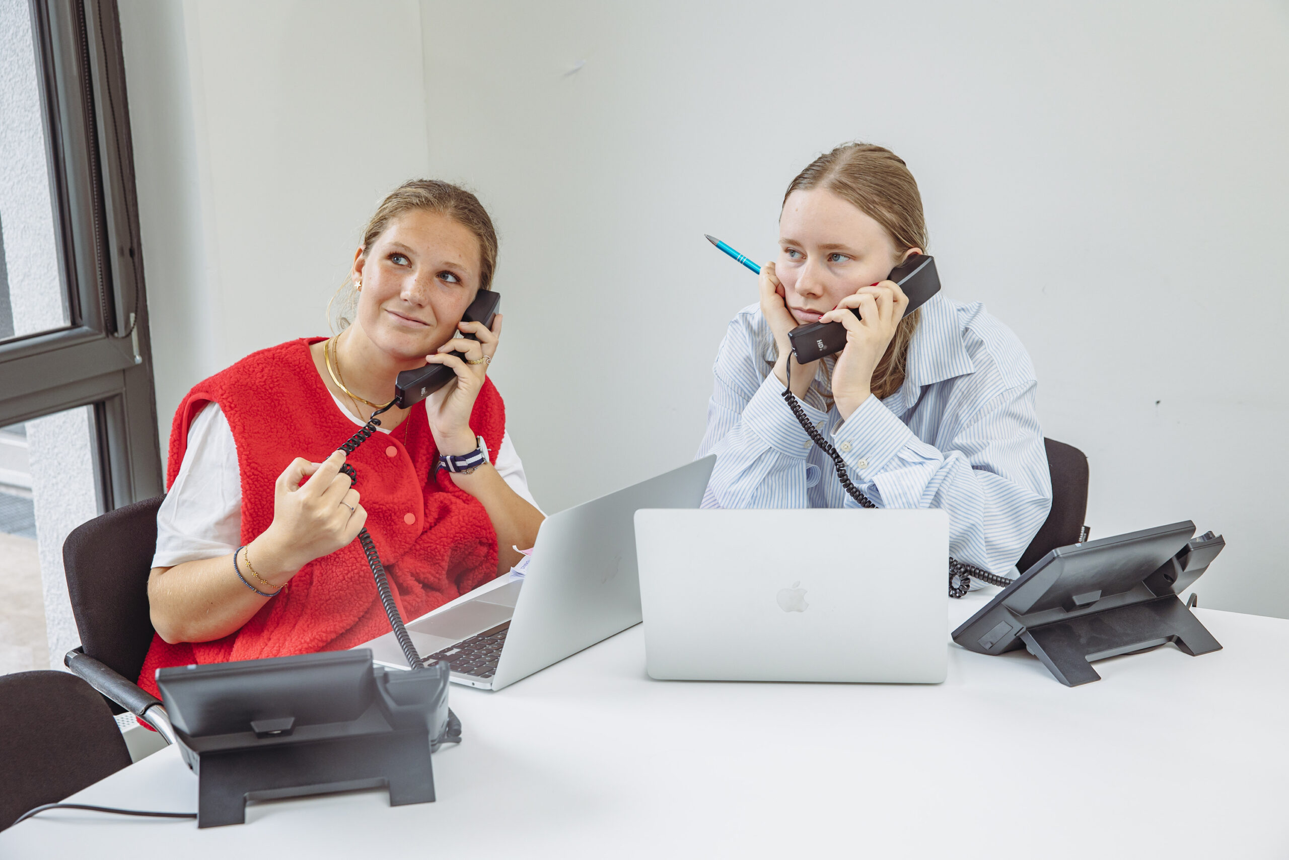 Tessa (l.) und Emilia (r.) sitzen am Telefon und versuchen Arzttermine zu bekommen.