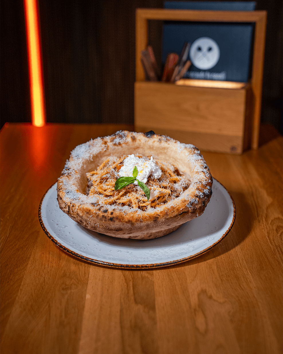 Das Nudelgericht wird in einer Bowl aus Pizzateig serviert.