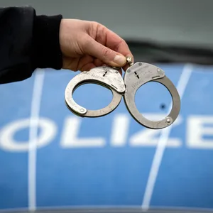 Ein Polizist hält ein Paar Handschellen