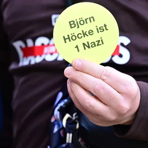 Vor dem Spiel gegen Stuttgart hielt St. Pauli-Präsident Oke Göttlich einen Anti-AfD-Sticker in die Kameras.