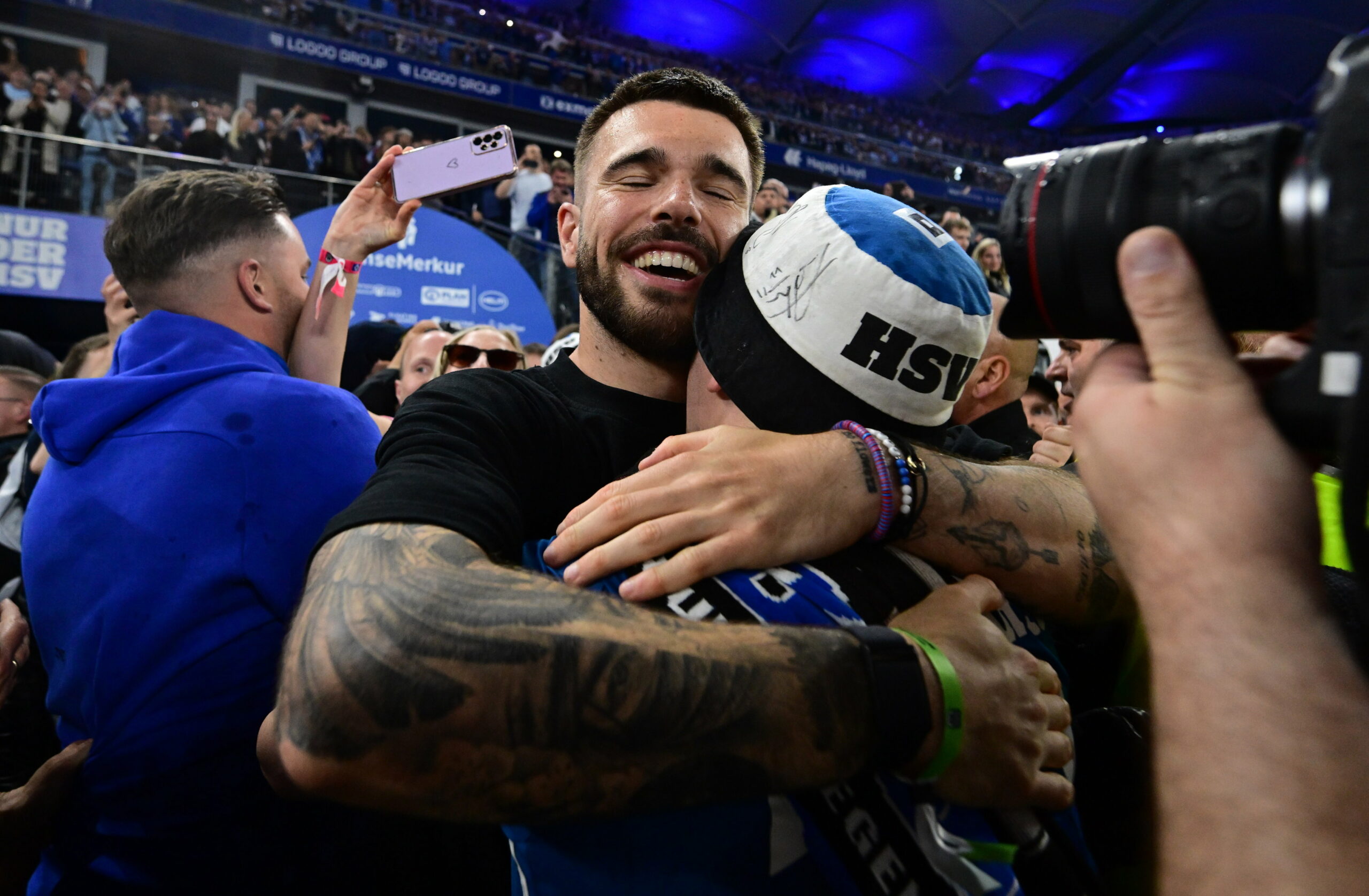 Mario Vuskovic umarmt einen HSV-Fan und lächelt