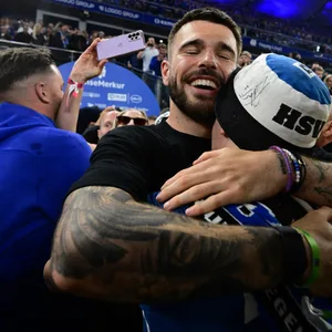 Mario Vuskovic umarmt einen HSV-Fan und lächelt