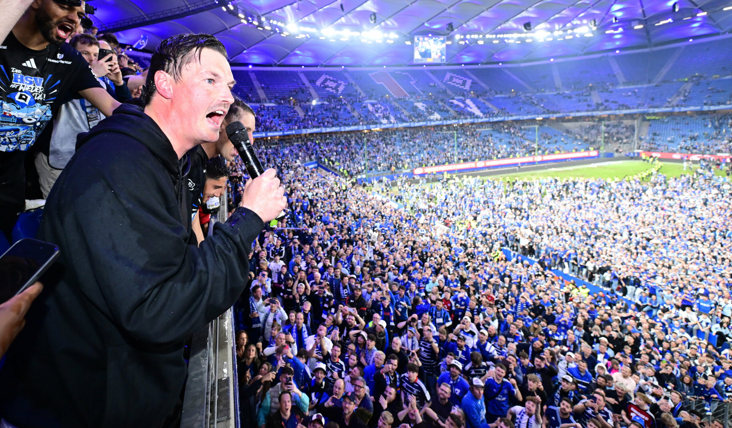 Merlin Polzin spricht auf der HSV-Aufstiegsparty in ein Mikro zu den Fans