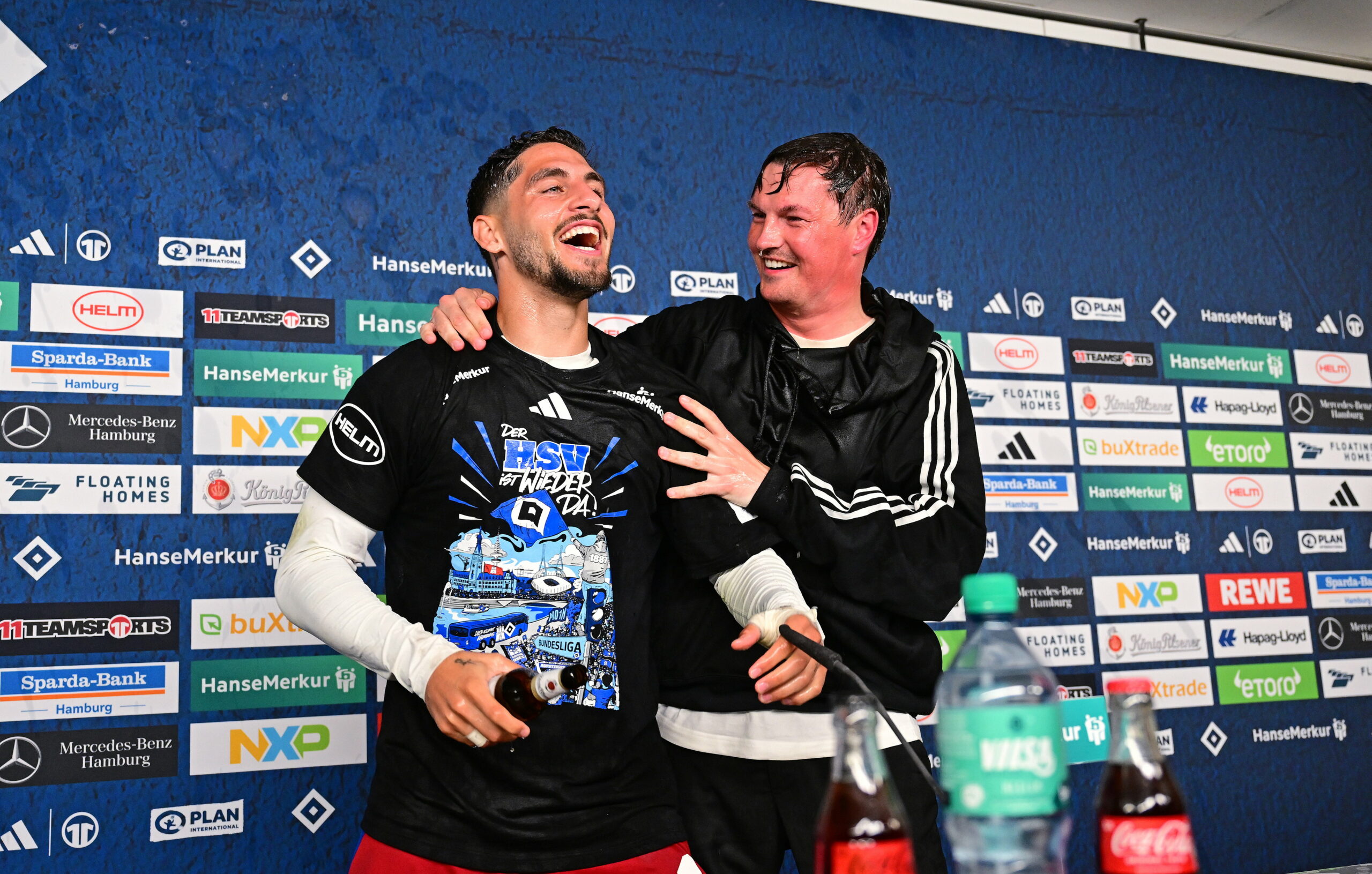 Merlin Polzin umarmt Ludovit Reis auf dem PK-Podium