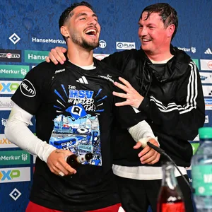 Merlin Polzin umarmt Ludovit Reis auf dem PK-Podium