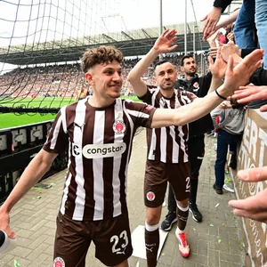 Philipp Treu und Manolis Saliakas klatschen mit den Fans ab